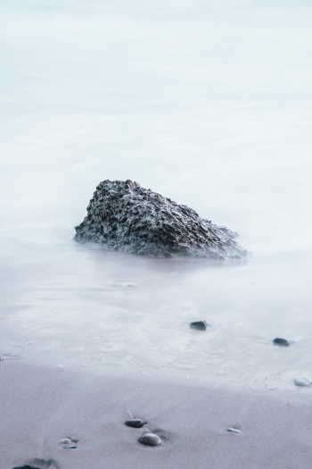 Long exposure shot of a rock on the beach Long exposure shot of a rock on the beach