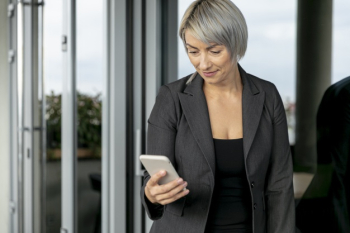 Low angle business woman looking at phone Free Photo