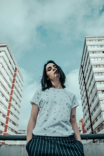 low-angle photo of woman standing between buildinfs