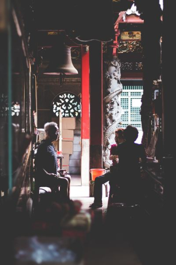 low-light photography of three people sitting on chairs indoors low-light photography of three people sitting on chairs indoors