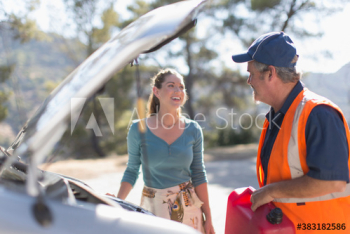 Male roadside assistance worker helping woman with vehicle breakdown Male roadside assistance worker helping woman with vehicle breakdown