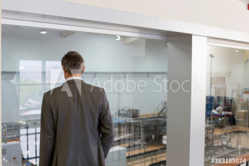 Male supervisor watching factory floor Male supervisor watching factory floor