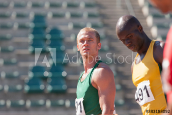 Male track and field athletes on sunny running track Male track and field athletes on sunny running track