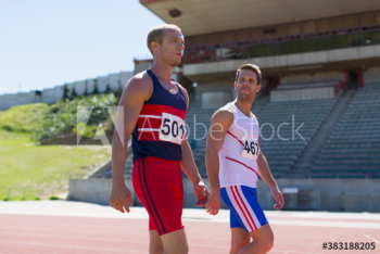 Male track and field athletes on sunny running track Male track and field athletes on sunny running track