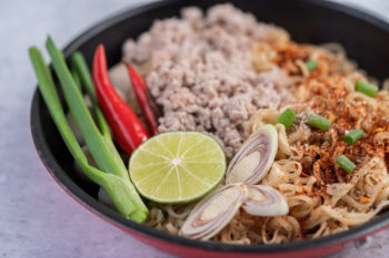 Mama with minced pork in a frying pan. Free Photo