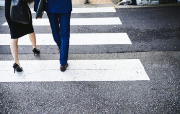man and woman crossing pedestrian lane man and woman crossing pedestrian lane