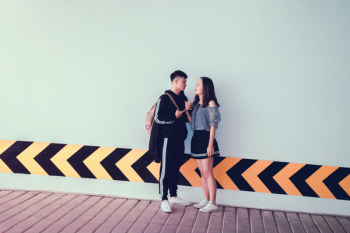 Man and Woman Looking at Each Other Near Wall