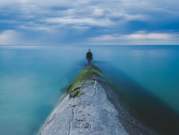 man beside body of water man beside body of water
