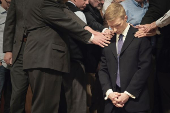 man bowing his head on another man man bowing his head on another man