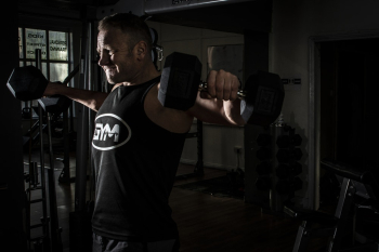 Man Exercising at the Gym With Fixed Weight Dumbbells Man Exercising at the Gym With Fixed Weight Dumbbells
