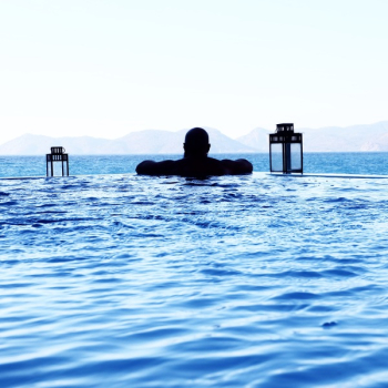 Man Floating on Pool in Front of Sea Man Floating on Pool in Front of Sea