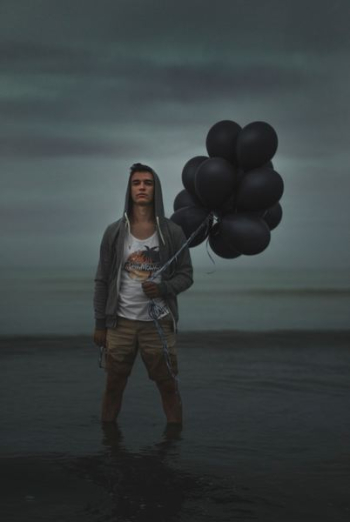 man holding balloons while on water man holding balloons while on water