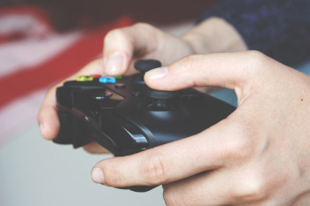 Man Holding Black Game Controller Man Holding Black Game Controller