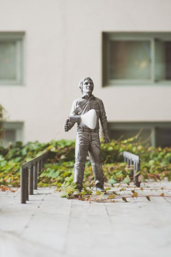 man holding bulb statue near building