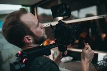 Man Holding Camera in Gimbal Close-up Photography Man Holding Camera in Gimbal Close-up Photography