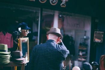 man holding his brown fedora hat facing backwards man holding his brown fedora hat facing backwards