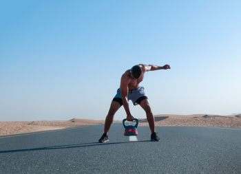 Man Holding Kettlebell on Road Man Holding Kettlebell on Road