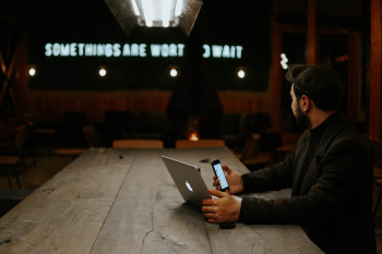 Man Holding Laptop and Smartphone Man Holding Laptop and Smartphone