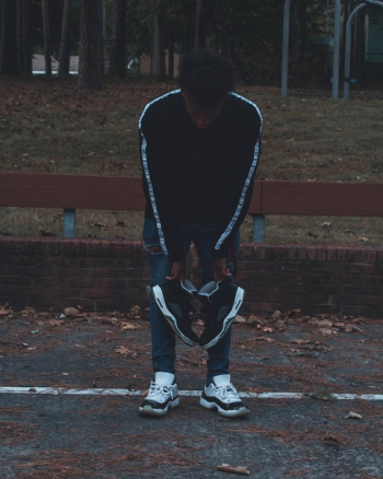 Man Holding Pair of Black Athletic Shoes