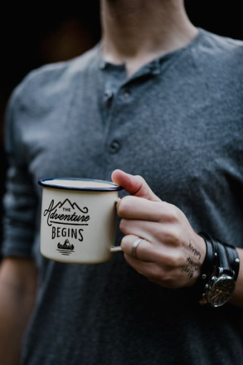 man holding white ceramic mug