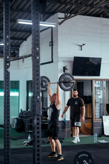 Man In Black Tank Top Lifting Barbell At The Gym Man In Black Tank Top Lifting Barbell At The Gym