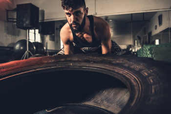 Man in Black Tank Top Lifting Vehicle Tire Man in Black Tank Top Lifting Vehicle Tire