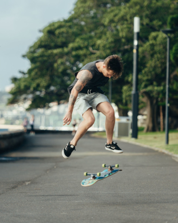 Man in Black Tank Top on Road Doing Skateboard Tricks Man in Black Tank Top on Road Doing Skateboard Tricks