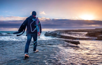 man in blue jeans walking on gray soil man in blue jeans walking on gray soil