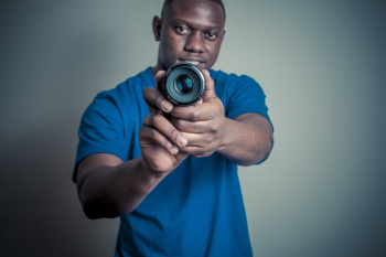 Man In Blue Shirt Holding Camera Lens Man In Blue Shirt Holding Camera Lens