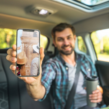 Man in car showing smartphone mockup Free Psd