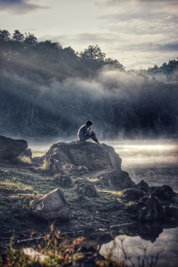 Man in Gray Shit Sitting on Rock Boulder Man in Gray Shit Sitting on Rock Boulder