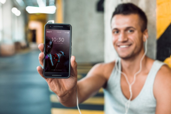 Man in gym holding smartphone mockup Free Psd Man in gym holding smartphone mockup Free Psd
