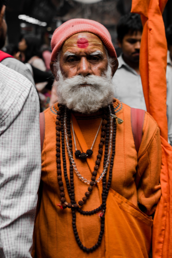 Man in Orange Suit With Red Marking on Forehead Man in Orange Suit With Red Marking on Forehead