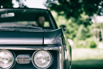 man inside black muscle car man inside black muscle car