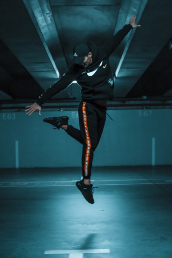Man Jumping And Reaching His Left Leg In Mid Air Man Jumping And Reaching His Left Leg In Mid Air
