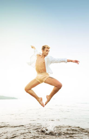 man jumping near seashore man jumping near seashore