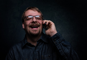 Man Laughing While Using Cellphone Man Laughing While Using Cellphone
