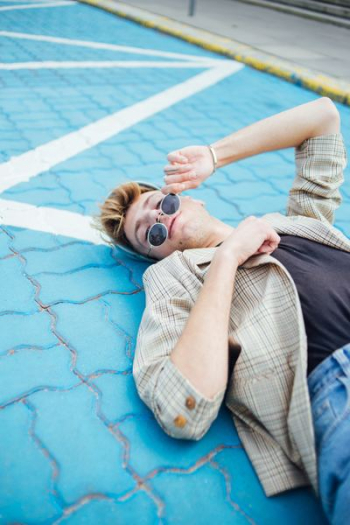 man lying on blue pavement