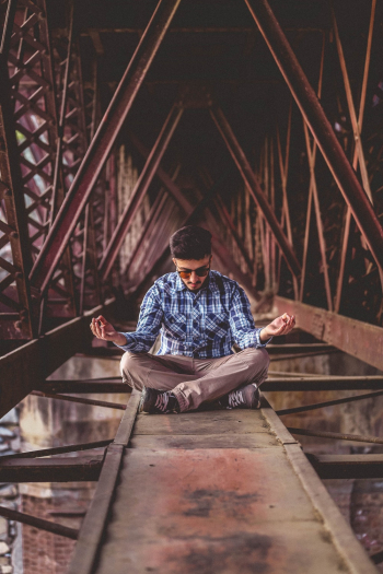 Man Meditating on Metal Surface Man Meditating on Metal Surface