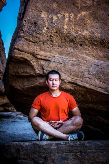 Man Meditating Under Rock Man Meditating Under Rock