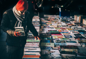 man picking up book ob book sale man picking up book ob book sale