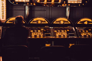 man playing arcade machine man playing arcade machine
