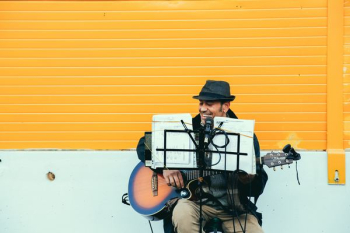 man playing brown and black acoustic guitar man playing brown and black acoustic guitar