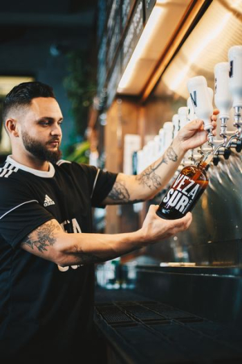 man pouring liquid on bottle man pouring liquid on bottle