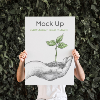 Man presenting poster mockup in front of leaves Free Psd