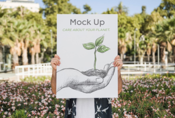 Man presenting poster mockup in front of park Free Psd