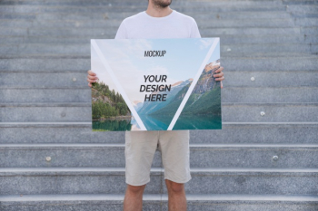 Man presenting poster mockup in front of stairs Free Psd