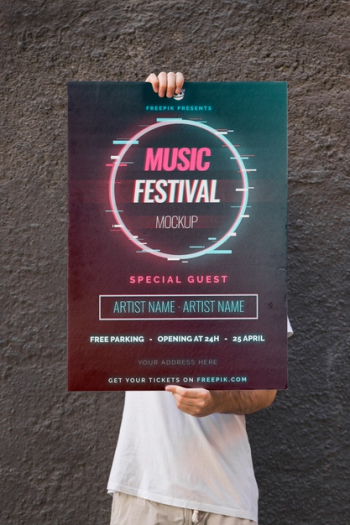 Man presenting poster mockup in front of wall Free Psd