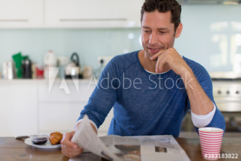 Man reading newspaper and enjoying breakfast Man reading newspaper and enjoying breakfast