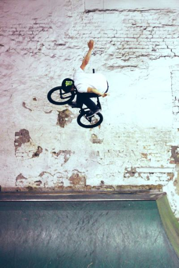 man riding black BMX bike doing bike tricks